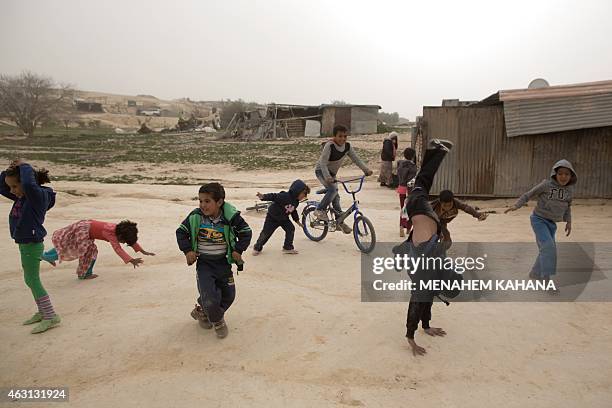 Israeli Bedouin children play in the yard of their home during a sandstorm in the Bedouin town of Segev Shalom, in the Negev desert, near the...