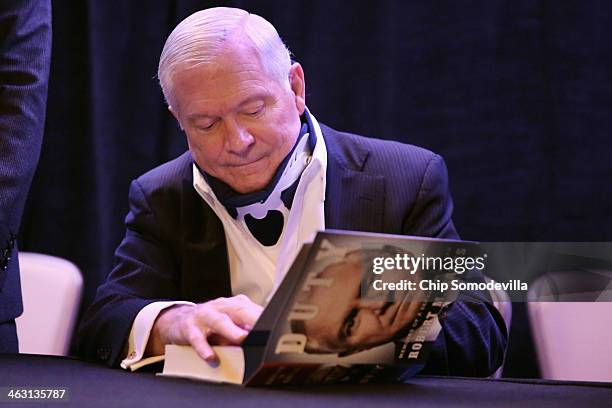 Former US Secretary of Defense Robert Gates signs copies of his new book, "Duty" during an event sponsored by Politico at the Mayflower Renaissance...