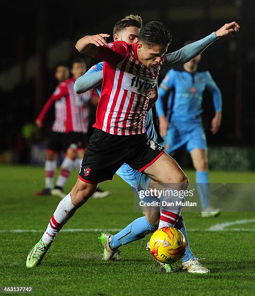 Tom Nichols of Exeter City holds off Greg Taylor of Cambridge United during the Sky Bet League Two match between Exeter City and Cambridge United at...