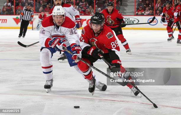 Cory Conacher of the Ottawa Senators skates the puck wide on Travis Moen of the Montreal Canadiens at Canadian Tire Centre on January 16, 2014 in...