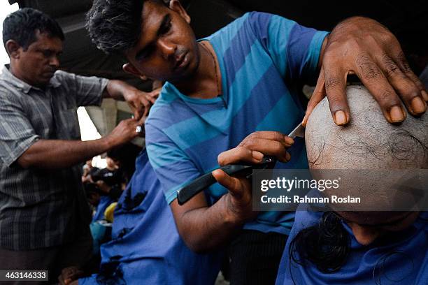 Young female devotee shaves her head as part of the cleansing ritual during the Thaipusam festival on January 17, 2014 in Kuala Lumpur. Thaipusam is...
