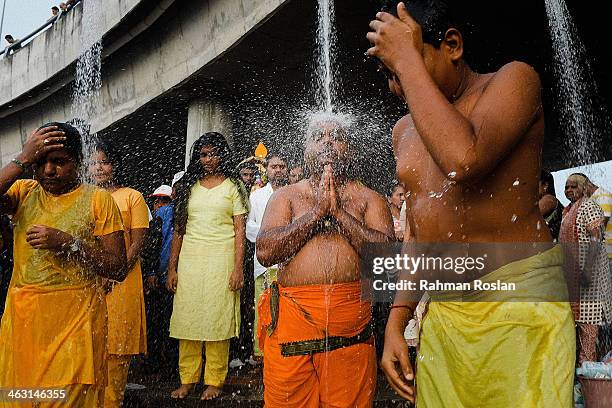 Devotees perform a cleansing ritual underneath a shower during the Thaipusam festival on January 17, 2014 in Kuala Lumpur. Thaipusam is a Hindu...