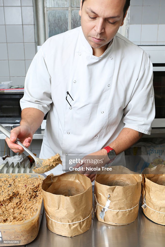 Artisan baker making Christmas cakes.