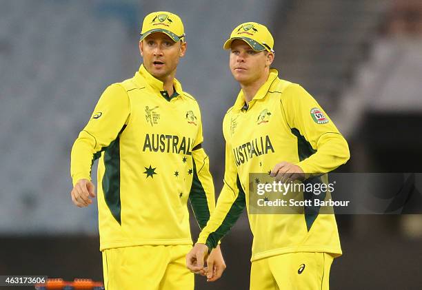 Steven Smith and captain Michael Clarke of Australia talk in the field during the Cricket World Cup warm up match between Australia and the United...