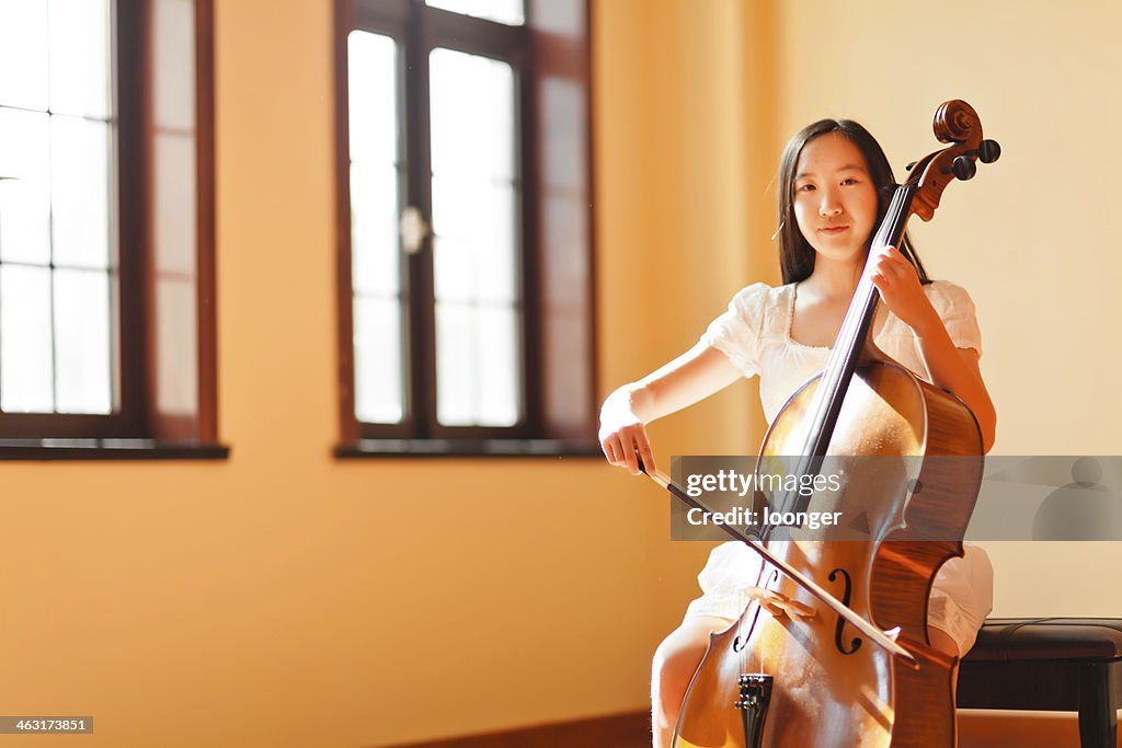 East asian teenage girl playing cello