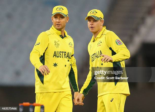 Steven Smith and captain Michael Clarke of Australia talk in the field during the Cricket World Cup warm up match between Australia and the United...