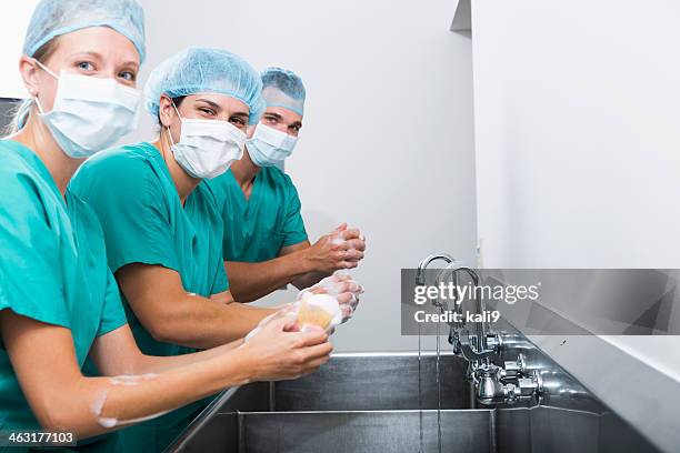 surgeons washing hands - schoonschrobben stockfoto's en -beelden