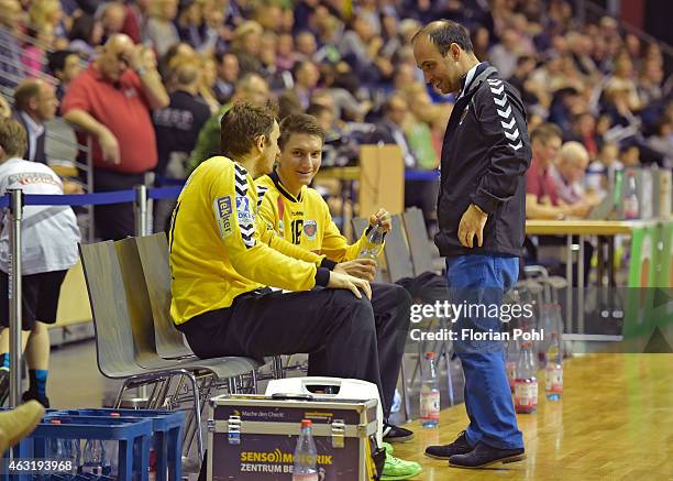 Assistant coach Alexander Haase speaks with Petr Stochl and Angelo Grunz of Fuechse Berlin during the game between Fuechse Berlin and GWD Minden on...