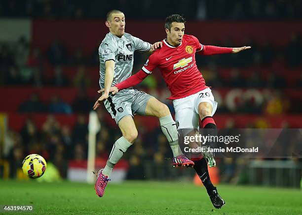 Robin van Persie of Manchester United is challenged by David Jones of Burnley during the Barclays Premier League match between Manchester United and...