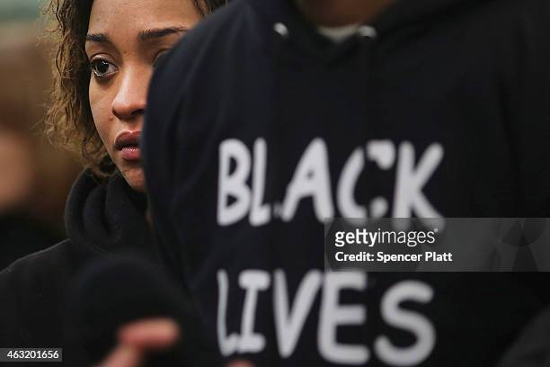 Protesters stand in a Brooklyn court after New York City police officer Peter Liang was charged with manslaughter, official misconduct and other...