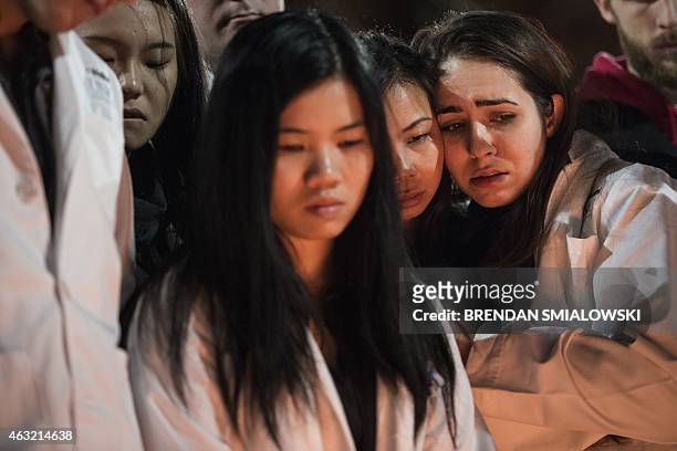 Dentistry students and others huddle together during a vigil at the University of North Carolina following the murders of three Muslim students on...