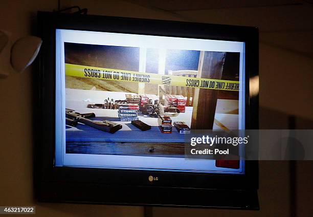 Crime scene photos from the Rough Creek Lodge and Resort where the deaths occurred are shown on television monitors during the capital murder trial...