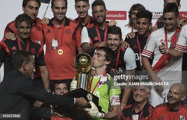 River Plate's goalkeeper Marcelo Barovero kisses the Recopa Sudamericana 2015 trophy next to Conmebol President Miguel Angel Napout after defeating...