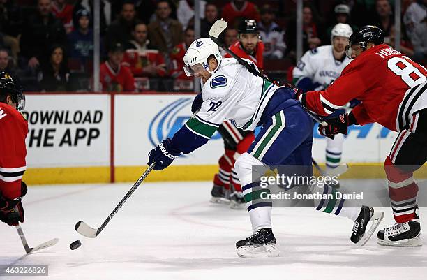 Daniel Sedin of the Vancouver Canucks shoots the game-winning goal under pressure from Marian Hossa of the Chicago Blackhawks at the Chicago...