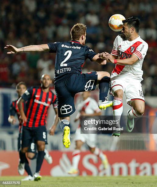 Ariel Rojas of River Plate jumps to head the ball with Mauro Cetto of San Lorenzo during a second leg match between San Lorenzo and River Plate as...