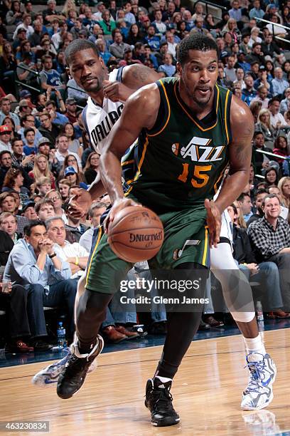 Derrick Favors of the Utah Jazz drives against Bernard James of the Dallas Mavericks on February 11, 2015 at the American Airlines Center in Dallas,...