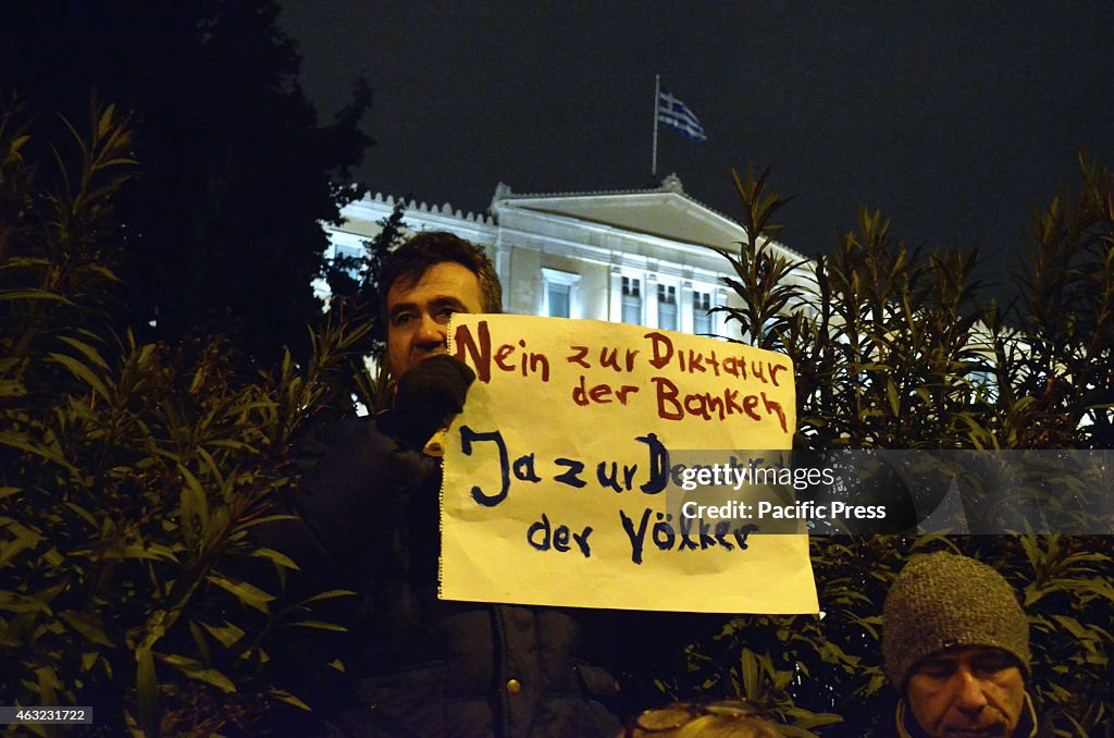 A demonstrator stands in front of the Greek parliament with...