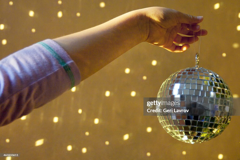 Person holding a miniature disco ball