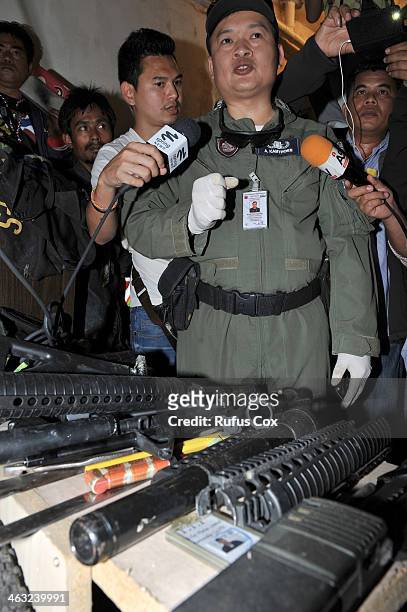 Police ordnance officer gives an interview to media after a small arms cache is found in a shophouse near the scene of earlier bomb attack on an...