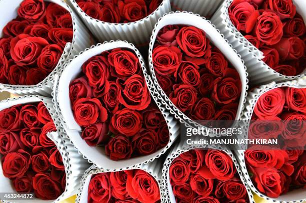 Red roses of the premium 'Taj Mahal' variety are stacked by a buyer after an auction at the International Flower Auction Bangalore centre on February...