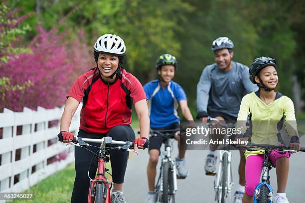 black family riding bicycles together - women road cycling stock pictures, royalty-free photos & images