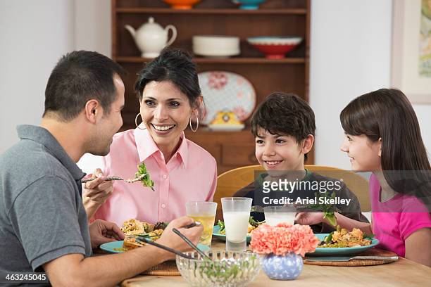 hispanic family eating dinner together - milk family stockfoto's en -beelden