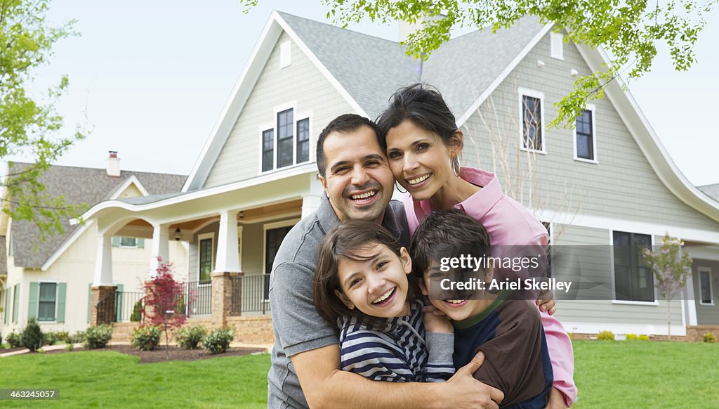 Hispanic family smiling outside house