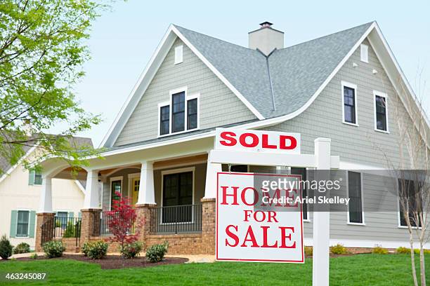 house with ""sold"" sign in front yard - sold house stock-fotos und bilder