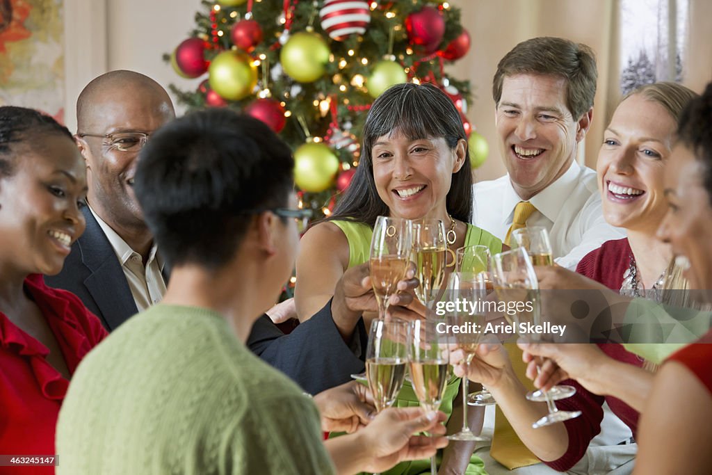 Friends toasting champagne glasses at Christmas dinner