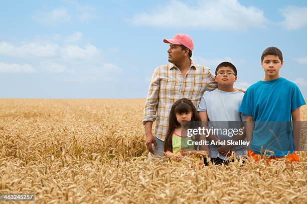 hispanic family standing in wheat field - migrant farmers fotografías e imágenes de stock