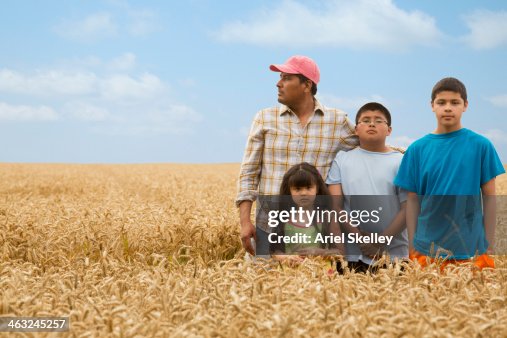 Hispanic family standing in wheat field