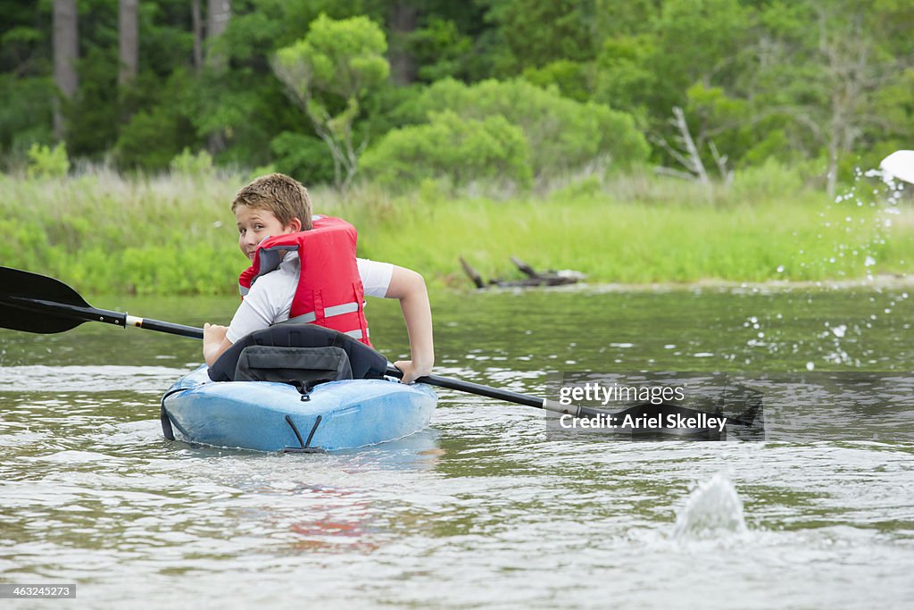 Caucasian boy kayaking in river