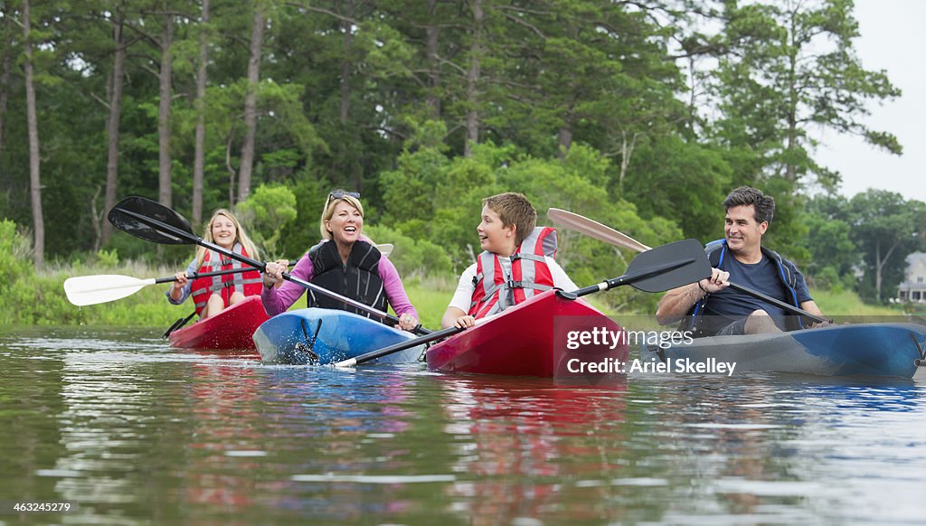 Caucasian family kayaking in river