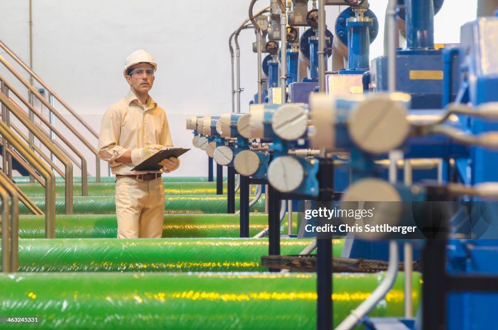 Hispanic worker checking machinery