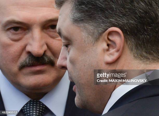 Ukrainian President Petro Poroshenko reacts as he stands close to his Belarus' counterpart Alexander Lukashenko after a summit aimed at ending 10...