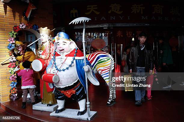 Chinese people walking out a shopping mall after buy decorations for the upcoming Chinese Lunar New Year of the sheep on February 12, 2015 in...