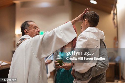 Priest anointing boy in church Priest anointing boy in church