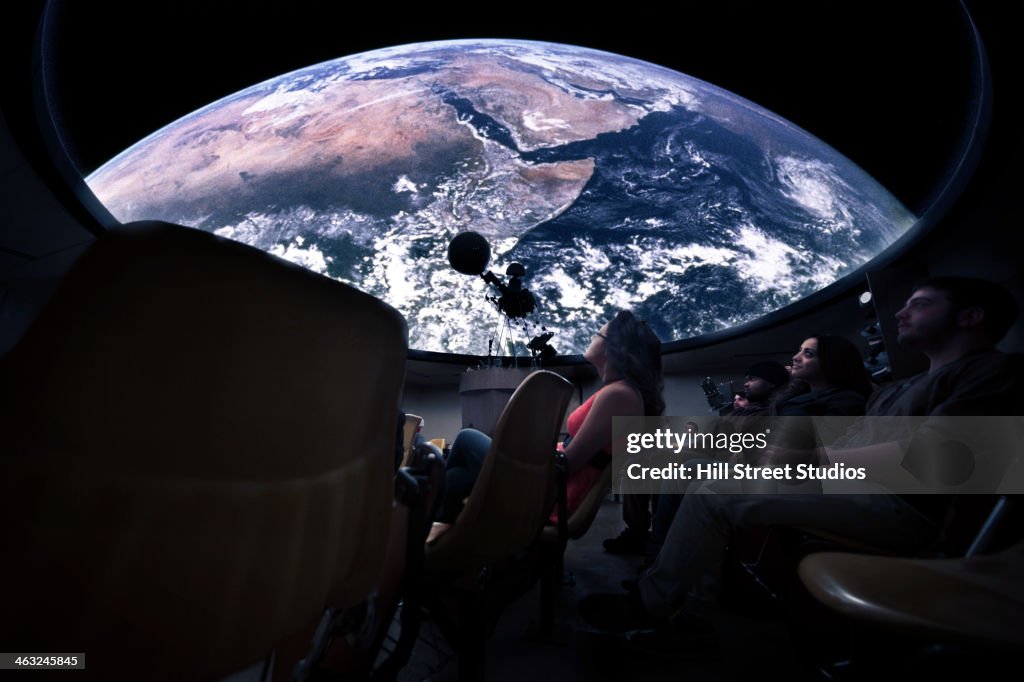 Students watching Earth in planetarium