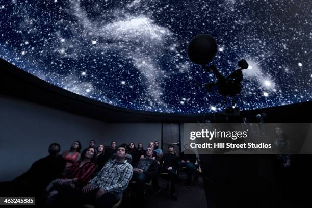 students watching constellations in planetarium - observatorium stock-fotos und bilder