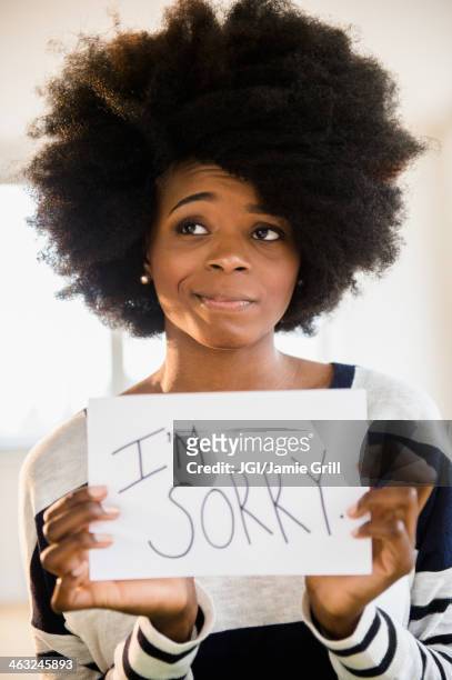 mixed race woman holding ""i'm sorry"" sign - m i a stock-fotos und bilder