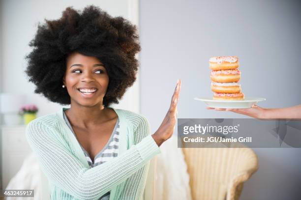 mixed race woman refusing donuts - rejection bildbanksfoton och bilder