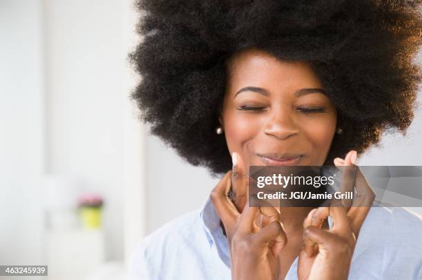 mixed race woman crossing her fingers - fingers crossed stock pictures, royalty-free photos & images