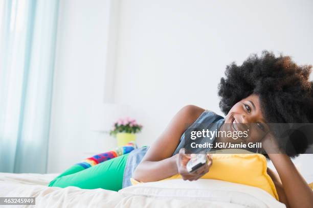 mixed race woman watching television - tv personality foto e immagini stock