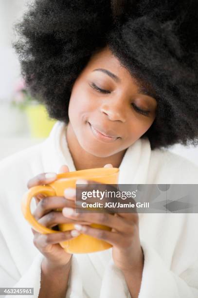 mixed race woman enjoying cup of coffee - mixed race woman drinking tea stock-fotos und bilder