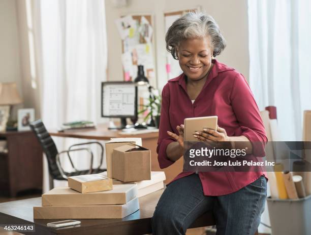 black woman using digital tablet - black business owner ストックフォトと画像