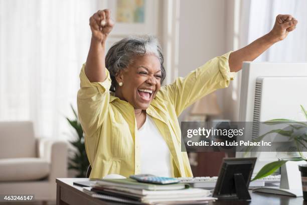 black woman cheering at computer - boa notícia imagens e fotografias de stock