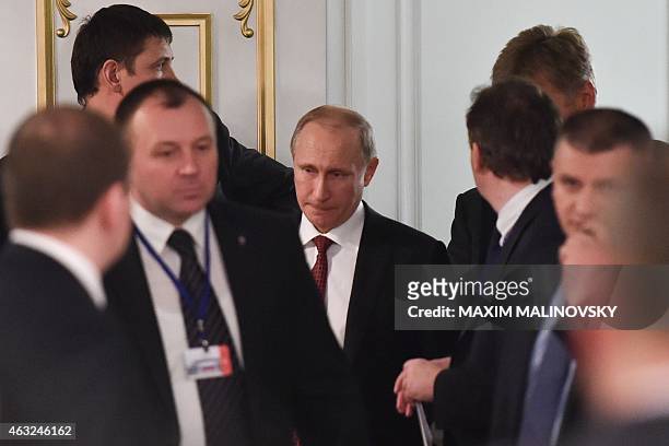 Russian President Vladimir Putin leaves a hall after a summit aimed at ending 10 months of fighting in Ukraine in Minsk on February 12, 2015. Putin...