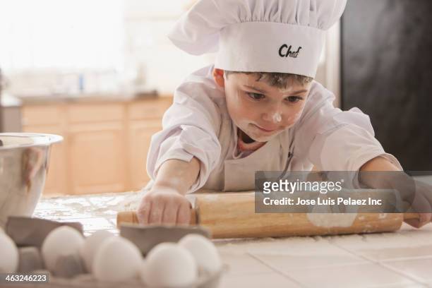 boy baking in chef's whites - kid chef stockfoto's en -beelden