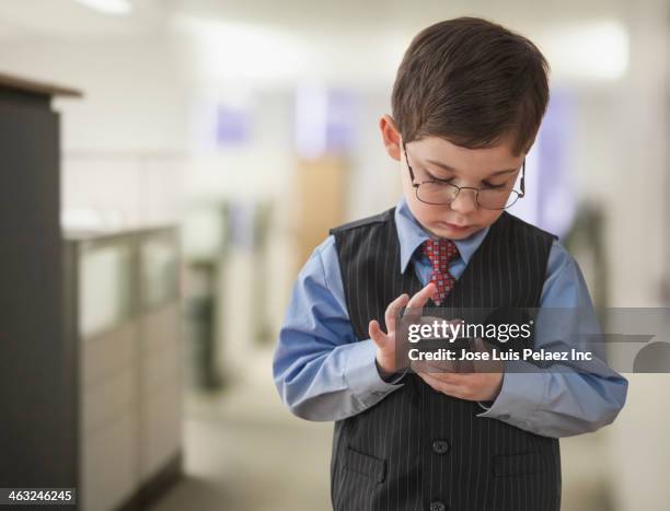 boy wearing businessman outfit in office - child prodigy stock-fotos und bilder