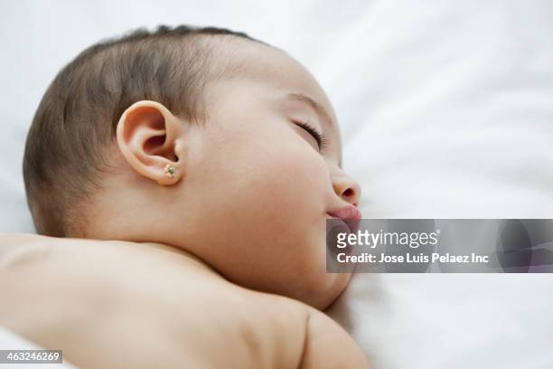 hispanic baby sleeping on bed - ohrring stock-fotos und bilder